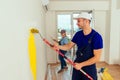 Smiling couple painting wall at home in yellow color Royalty Free Stock Photo