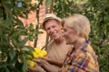 Smiling couple picking lemons in the garden