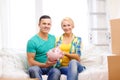 Smiling couple with piggybank in new home Royalty Free Stock Photo