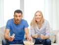 Smiling couple with popcorn cheering sports team Royalty Free Stock Photo