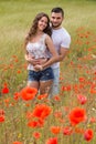 Smiling couple in poppies plants Royalty Free Stock Photo