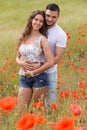 Smiling couple in poppies plants Royalty Free Stock Photo