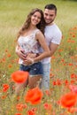 Smiling couple in poppies plants Royalty Free Stock Photo