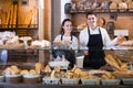 Smiling couple selling pastry and loaves