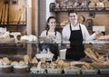 Smiling couple selling pastry and loaves