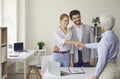 Smiling couple shaking hands with bank manager, real estate agent or loan advisor Royalty Free Stock Photo