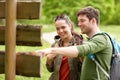 Smiling couple at signpost with backpacks hiking