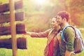 Smiling couple at signpost with backpacks hiking