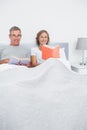 Smiling couple sitting in bed reading books Royalty Free Stock Photo