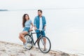 smiling couple sitting on bike on beach Royalty Free Stock Photo