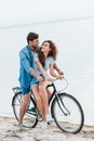 smiling couple sitting on bike on beach Royalty Free Stock Photo