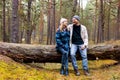 couple sitting and resting on fallen tree after walk in autumn park Royalty Free Stock Photo