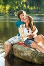 Smiling couple sitting on a rock romantic