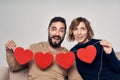 Smiling couple sitting on sofa holding four heart shape garland Royalty Free Stock Photo