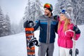 smiling couple skiing and snowboarding enjoying in snowy mountains together Royalty Free Stock Photo