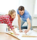 Smiling couple smearing wallpaper with glue Royalty Free Stock Photo