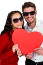 Smiling couple with sunglasses holding paper heart Royalty Free Stock Photo