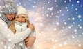 Smiling couple in sweaters over snow background