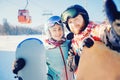 Smiling couple taking selfie together with snowboards background snowy mountain ski resort. Concept winter sports travel Royalty Free Stock Photo