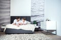 Smiling couple talking and lying on bed in cozy bedroom Royalty Free Stock Photo