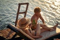 couple toasting with beer on a dock by the water during the summer sunset Royalty Free Stock Photo