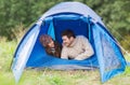 Smiling couple of tourists looking out from tent Royalty Free Stock Photo