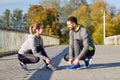 Smiling couple tying shoelaces outdoors