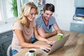 Smiling couple typing on laptop