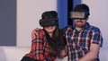 Smiling couple in virtual reality headset watching movie