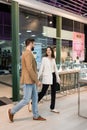 Smiling couple walking near showcases in