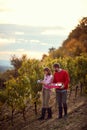 Smiling couple walking through vineyard. Family grape harvesting