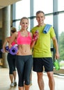 Smiling couple with water bottles in gym