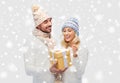 Smiling couple in winter clothes with gift box Royalty Free Stock Photo