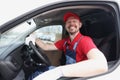 Smiling courier driver sits behind wheel of car Royalty Free Stock Photo