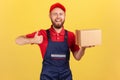 Smiling courier man holding cardboard box and showing thumb up, delivering parcel to client. Royalty Free Stock Photo