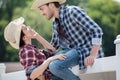 Smiling cowboy style couple flirting outdoors