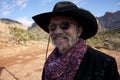 Smiling cowboy with sunglasses in red rocks