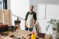 Smiling craftsman in apron standing near
