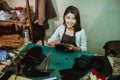 Smiling craftswoman holding pieces of tanned leather