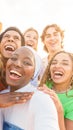 Smiling crazy multi-ethnic people taking selfies during sunset