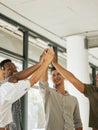 Smiling creative business team standing in office and giving high five during team building. Diverse business people Royalty Free Stock Photo