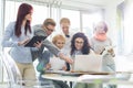 Smiling creative businesspeople working on laptop at desk in office Royalty Free Stock Photo