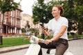 Smiling curly business man holding smartphone and looking away Royalty Free Stock Photo