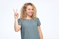 Smiling curly caucasian female model doing peace