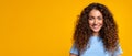 Smiling curly-haired woman on yellow background, panorama, copy space Royalty Free Stock Photo