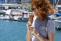 Curly haired young woman with ice cream by the seaside Royalty Free Stock Photo