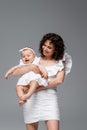 Smiling curly mother holding cheerful baby Royalty Free Stock Photo