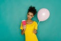 Happy girl with coffee cup and balloon at studio background