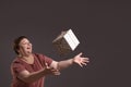 smiling curvy woman throws up gift, play with present box on grey background