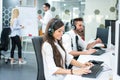 Smiling customer support operators working on computers at office. Royalty Free Stock Photo